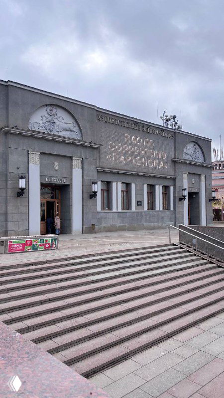 Фасад старейшего кинотеатра «Художественный» на Арбатской площади с широкими ступенями, входом и исторической надписью над дверями здания.