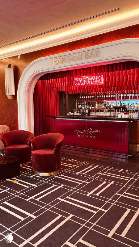 Коктейль‑бар в ретро‑стиле с красной барной стойкой и уютными бархатными креслами — небольшая лаунж‑зона в интерьере кинотеатра.