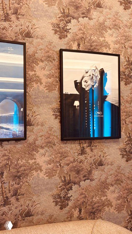 Детали оформления стен: картины в рамках на фоне декоративных обоев, элемент интерьерного дизайна исторического кинозала и фойе.