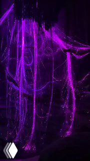 Фиолетовые световые струи и вертикальные пучки создают эффект капель или нитей света — часть кинестетической инсталляции выставки "Геометрия чувств".