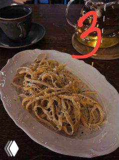 Тарелка с тонкой пастой, посыпанной тёртым сыром и чёрным перцем — паста №3 в подборке московских заведений, тёплый интерьер.