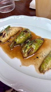 Тарелка с зелёными патиссонами в соусе, поданная на белой фарфоровой тарелке — часть авторского меню ресторана.