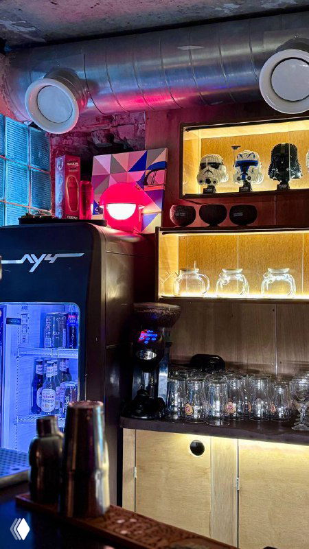 Барная стойка в ретро‑стиле с полками, подсвеченными тёплым светом, стеклянной посудой и элементами декора в духе 70-х, атмосферный кадр.