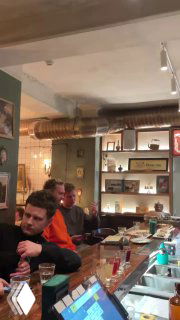 Гости за барной стойкой в тёплом интерьере: люди, общение и повседневная атмосфера заведения в Ростове-на-Дону.