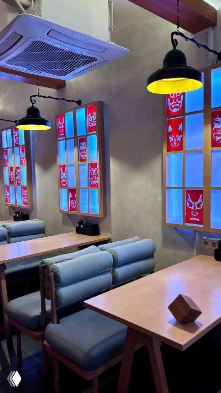 Вид на тот же угол зала: мягкие сидения, столы и лампы под потолком, атмосфера сетевого бара на туристической улице.