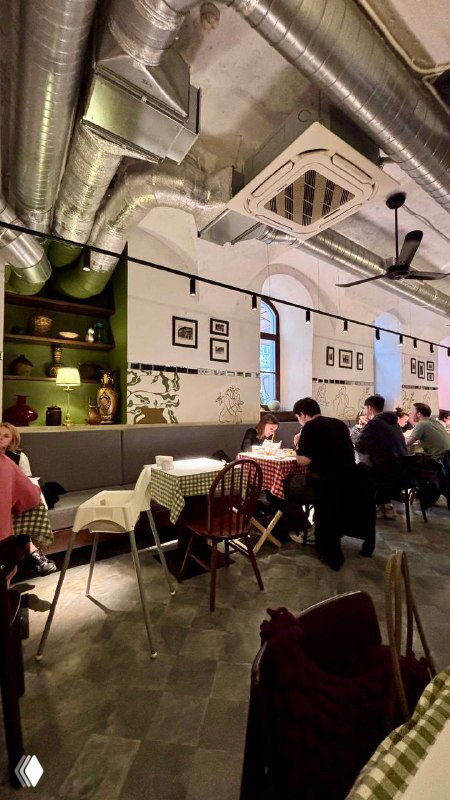 Интерьер Osteria by Mandy's: залы с клетчатыми скатертями, гости за столами и открытая система вентиляции под потолком ресторана