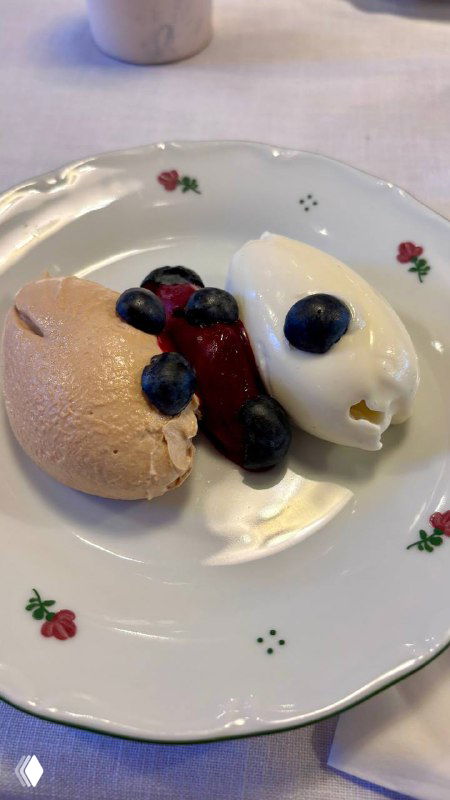 Десертный состав: взбитый топлёный творог рядом с шариком сорбета из чёрной смородины и ягодами, минималистичная подача на фарфоровой тарелке.