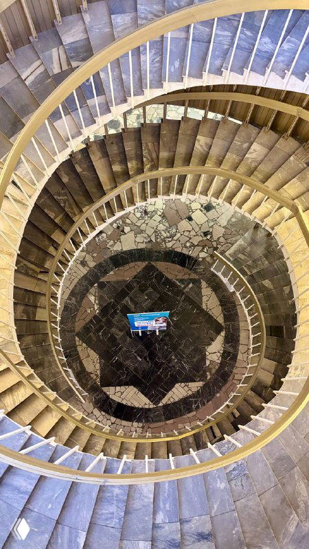 Вид сверху на двойную спиральную лестницу в библиотеке РНИМУ: центральный мозаичный пол и узор лестницы, кадр с высоты, архитектурный ракурс.