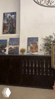 Стена с картинами и декоративными элементами в трапезной, настенные работы и детали интерьера в религиозном пространстве.