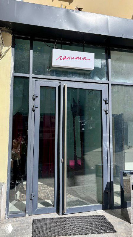 Вход в кафе «Лолита» с вывеской над стеклянными дверями: фасад и ступеньки, вид с улицы на входную группу заведения на Яузской.