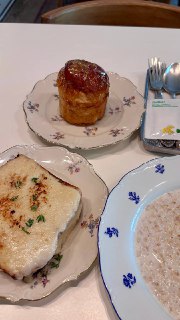 Тарелки с маленьким куличом в карамельной шапке, овсяной кашей и запечённым тостом — общий вид сервировки на столе