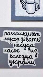 Фотография настенной работы с рукописным текстом на русском языке: фраза кистью на сером фоне, часть ироничной экспозиции в музее.