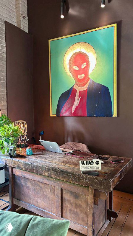 Комната с яркой поп-арт картиной над ретро-столом, приёмная зона с декоративными предметами и зеленью, интерьерный акцент.