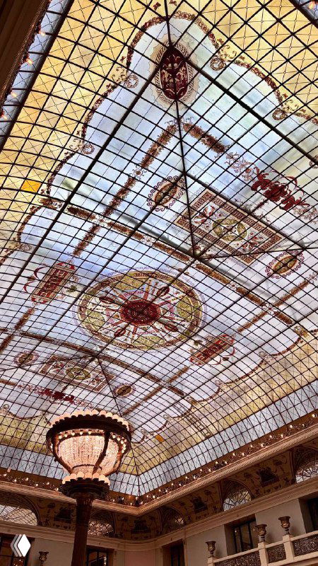 Витражная стеклянная крыша обеденного зала отеля Метрополь в Москве, декоративные орнаменты и центральная люстра, вид снизу
