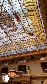 Вертикальный ракурс интерьера отеля Метрополь: витражная крыша, балконы и архитектурные детали в стиле модерн, высокое пространство