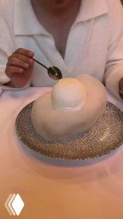 Белый сферический десерт подают на тарелке с узором — авторский десерт ресторана Christian, текстура и подача подчёркивают концепцию заведения в Москве