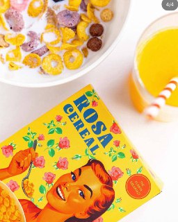 Композиция завтрака с миской хлопьев, коробкой Rosa Cereal и стаканом апельсинового сока в ярких винтажных тонах.