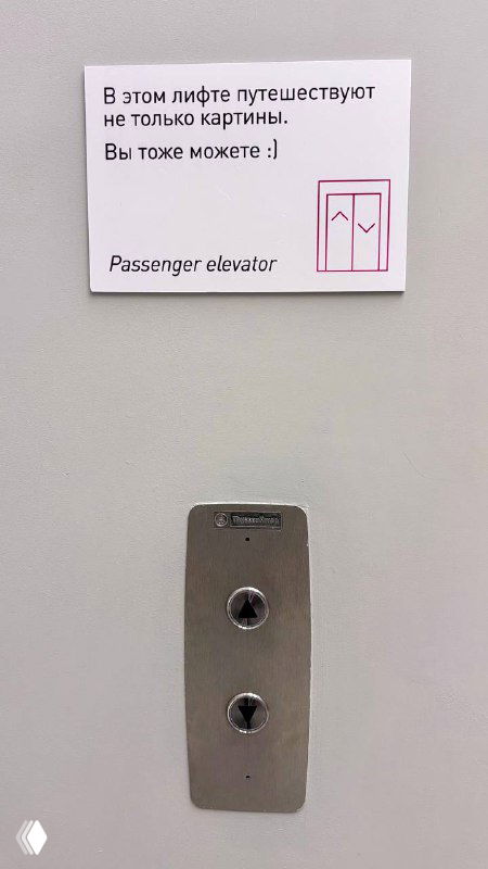 Табличка и панель лифта в музее с текстом о том, что в этом лифте путешествуют картины; вид кнопок и инструкции.