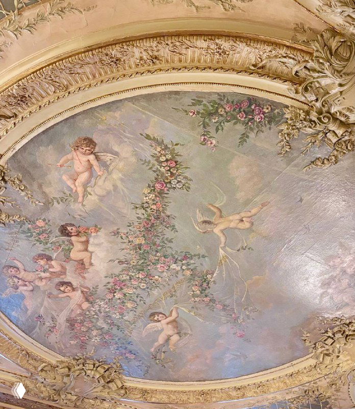 Роспись потолка в зале ресторана Savoy с купидонами, растительными гирляндами и позолоченной лепниной — вид на декор от посетителя.