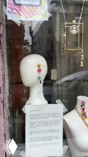 Витрина или перформанс с манекеном и яркими украшениями; бюст украшен странными аксессуарами в стиле мультфильмов, городская инсталляция.