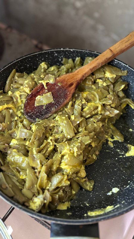 Близкий план готового дзвов лоби в сковороде: размешанная фасоль с яйцом, золотистая текстура и домашняя подача на кухне села.