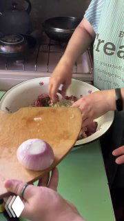 Мамины руки на кухонной доске: мелкие нарезки и лук для фарша, рядом миска с подготовленными ингредиентами — домашняя готовка шашлыка.