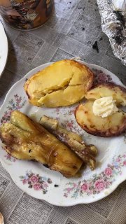Порезанный запечённый картофель и баклажан на тарелке, видно масляные нотки, сырой вид мякоти и аппетитная корочка
