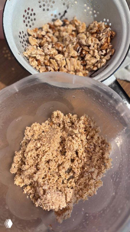 Измельчённые грецкие орехи в дуршлаге и крупно измельчённая паста из орехов в прозрачной миске — база начинки пахлавы.