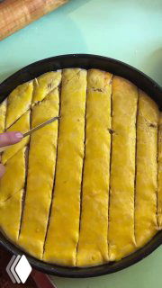 Разрезание заготовки на ромбики ножом перед выпеканием — видна ровная сетка разрезов на поверхности теста.