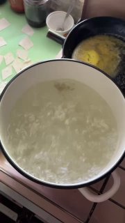 Кипящая кастрюля с солёной водой, вид сверху на пенящуюся поверхность во время варки кусочков теста.