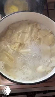 Кусочки теста в кипящей воде — вид процесса варки ленивых вареников, белые плавающие кусочки и пенная поверхность.