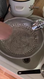 Процедура слива воды через дуршлаг, показана кухонная утварь и руки, вынимающие или процеживающие тесто.
