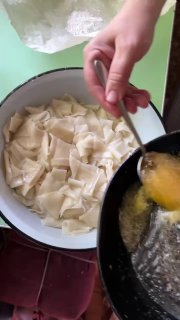 Добавление сливочного масла в варёные кусочки теста: вид ложки, растопленного масла и кастрюли на плите.
