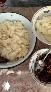 Порция отваренных кусочков теста в миске рядом с отдельной миской жареного лука — готовая подача татар бераги со сметаной по вкусу.