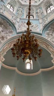 Фрагмент купола и люстры Знаменской церкви: декоративная лепнина, окультуренный купол и золотая подвесная люстра.