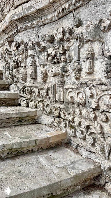 Крупный план ступеней с резными и барельефными элементами на территории усадьбы, видны орнаменты и следы времени на камне.