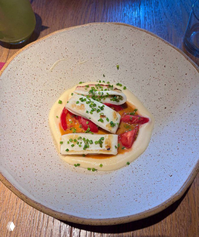 Тонко сервированное блюдо с кремовым соусом, ломтиками сыра и помидорами на глубокой тарелке в спокойной подаче Tacobar