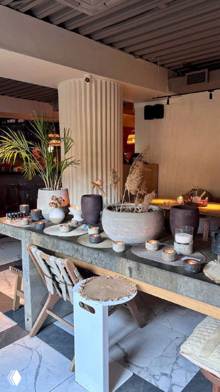 Декоративный стол с керамическими чашами и предметами интерьера в ресторане; отражение стильного дизайна и тёплой атмосферы Tacobar