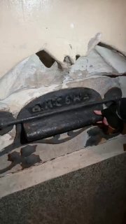 Крупный план старого металлического устройства или почтового ящика с надписями и следами коррозии на поверхности, фрагмент на улице.