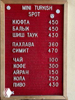 Доска меню Mini Turkish Spot с белыми буквами на красном фоне: кюфта, балык, шиш тау, пахлава, симит и напитки с ценами.