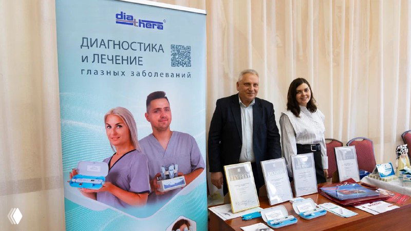 Стенд с тематикой диагностики и лечения глаз рядом с представителями компании и материалами о приборе ИГД-02 на выставочном столе.