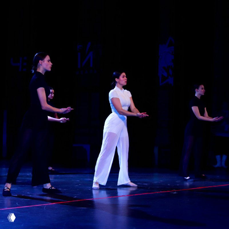 Молодые артисты выполняют сценическую постановку в повседневных костюмах на сцене конкурса, подготовка и координация движений, драматическое освещение.