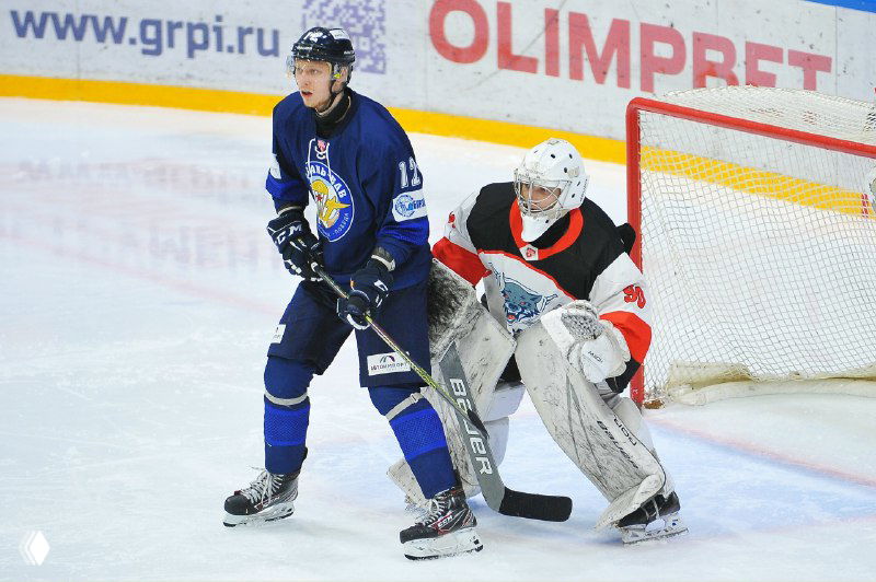 Игрок команды «Рязань-ВДВ» действует в атаке перед воротами соперника, на фото виден голкипер и часть рекламных бортиков арены