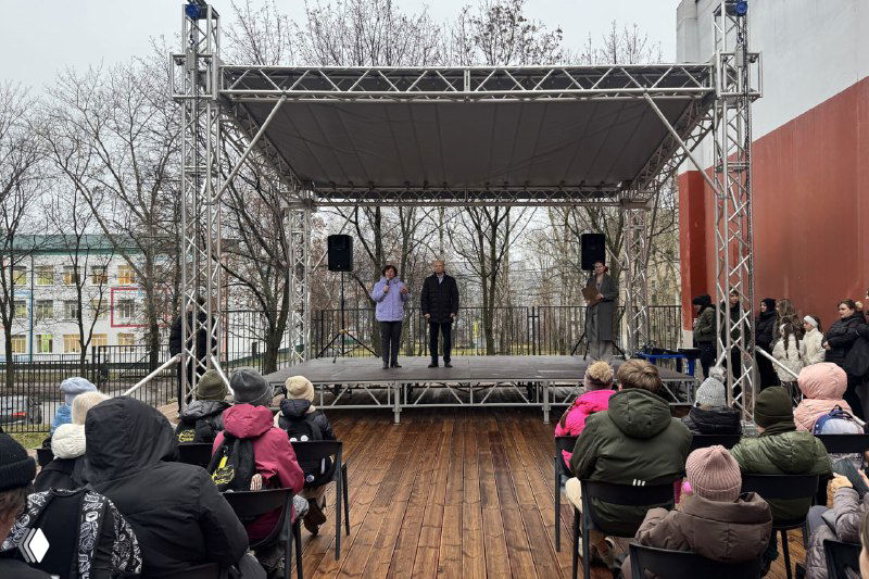 На фото новая уличная сцена у Рязанского Дворца молодёжи зимой: на сцене люди, перед ней располагается зрительская аудитория на деревянной площадке.