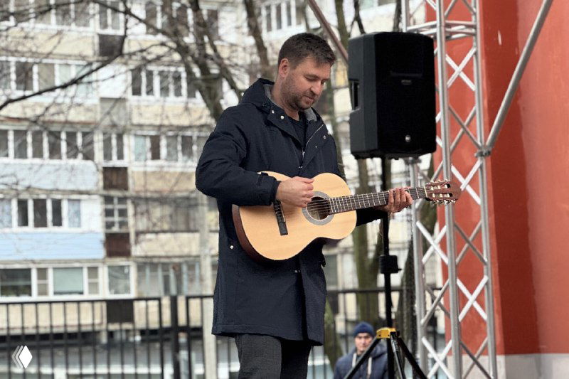 Директор Рязанского Дворца молодёжи Сергей Прошин играет на акустической гитаре во время первого выступления на новой уличной сцене перед слушателями.