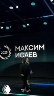 Сцена церемонии «Блогема» 2025: крупный экран с надписью «МАКСИМ ИСАЕВ», человек стоит на сцене во время вручения награды.