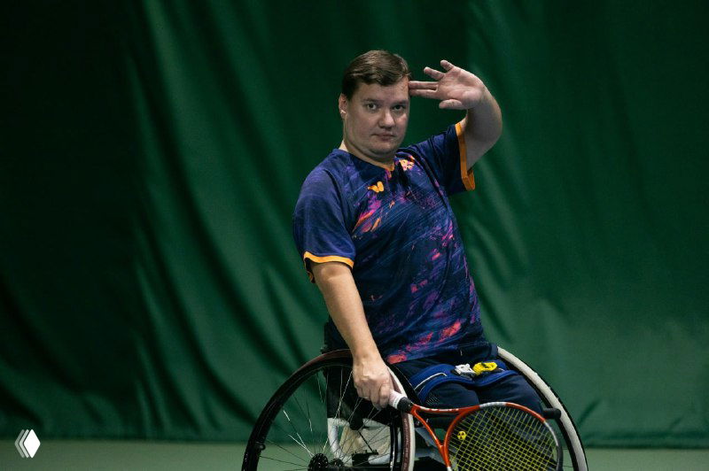 Теннисист на спортивной инвалидной коляске Алексей Лисовой держит ракетку на корте, кадр с соревнований «Осенний Кубок ФТР» в Москве