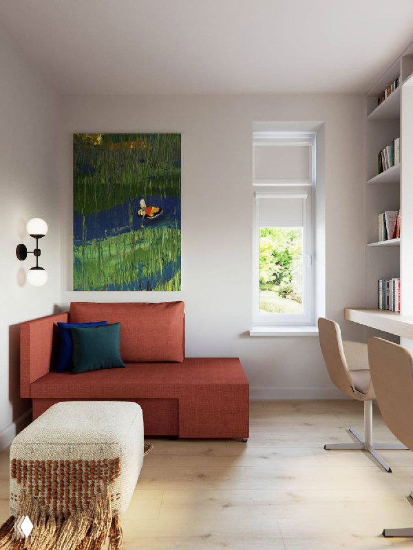 Небольшая жилого рабочего уголка с диваном и вертикальным ярким полотном над ним, окно приносит дневной свет, теплый и функциональный интерьер.