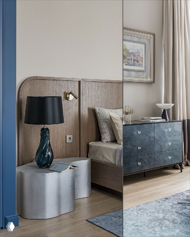 Угол спальни по мотивам Моне: прикроватный столик и округлённый пуф, тёмно-синяя лампа, часть синего шкафа и мягкая пастельная палитра в интерьере.