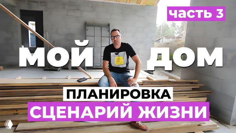 Автор сидит на стройплощадке будущего дома в полуготовом помещении; вокруг — блоки стен, деревянные панели и стройматериалы.